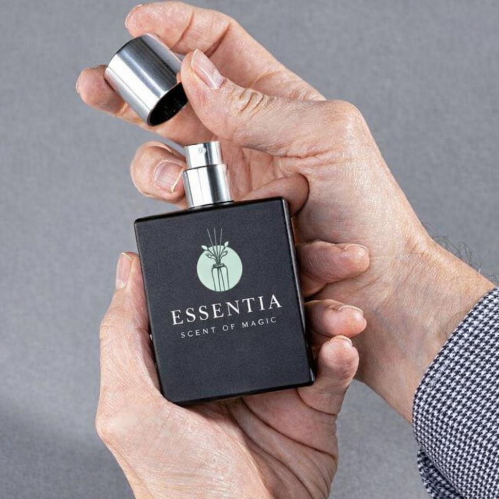 Essentia black perfume bottle held in hands with silver cap showcasing floral woody musk fragrance